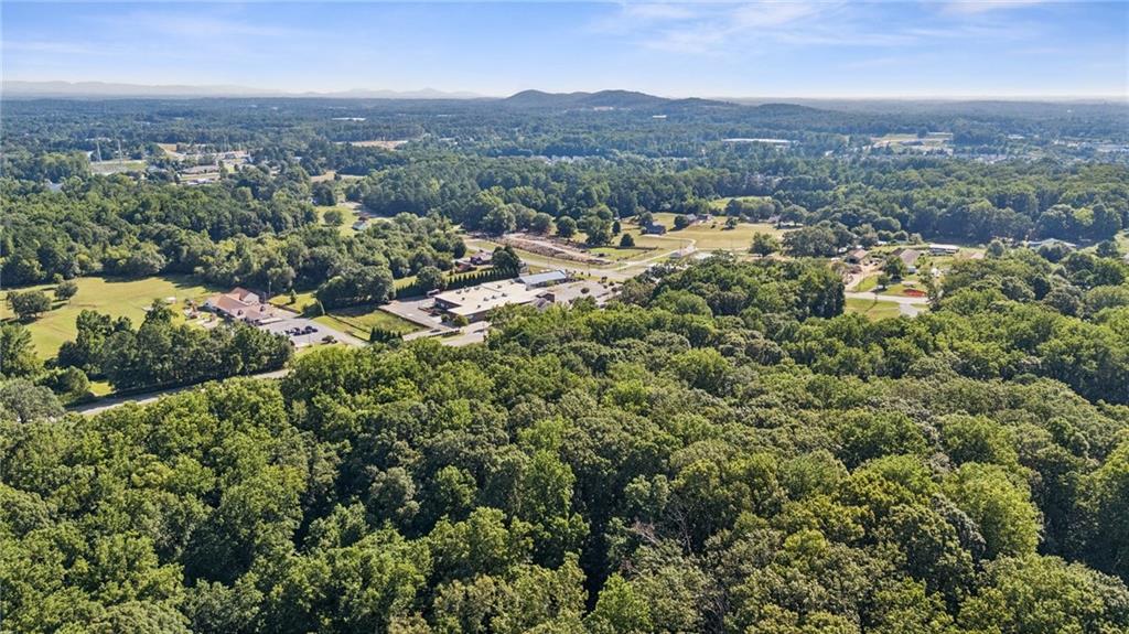 an aerial view of residential house with parking and trees