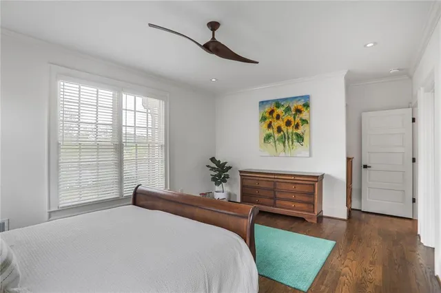 a bedroom with a bed and a dresser next to a window