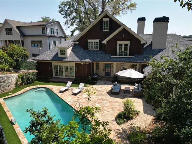 a view of a house with swimming pool and sitting area
