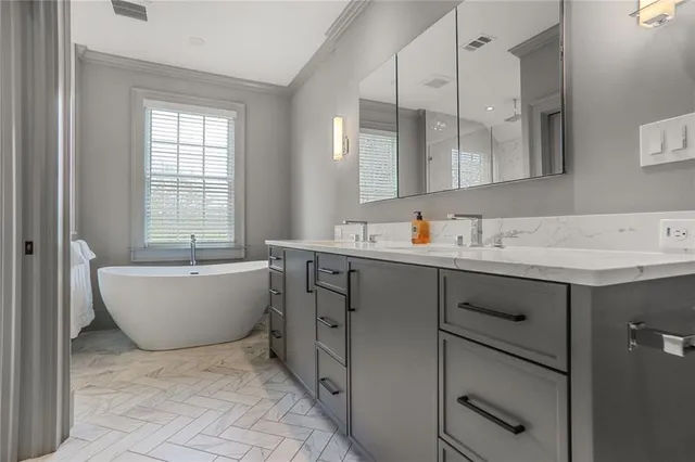 a bathroom with a bathtub a sink a mirror and a window