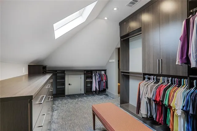 a view of walk in closet with clothes and shoes