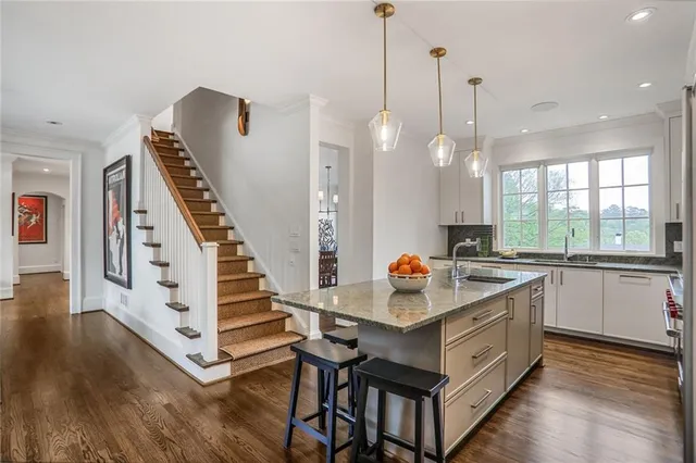 a open kitchen with stainless steel appliances granite countertop a stove and a wooden floor