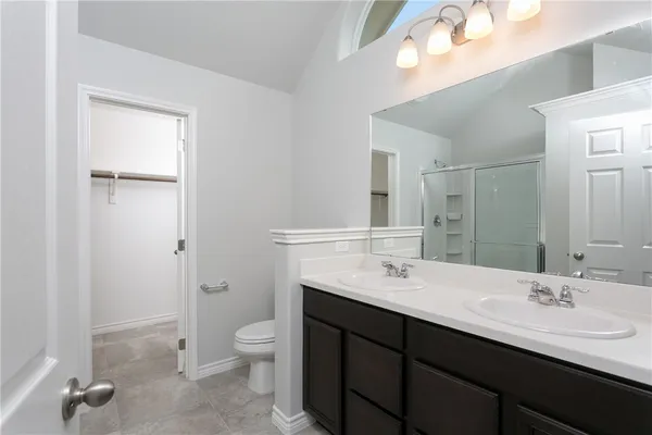 a bathroom with a double vanity sink toilet and a mirror
