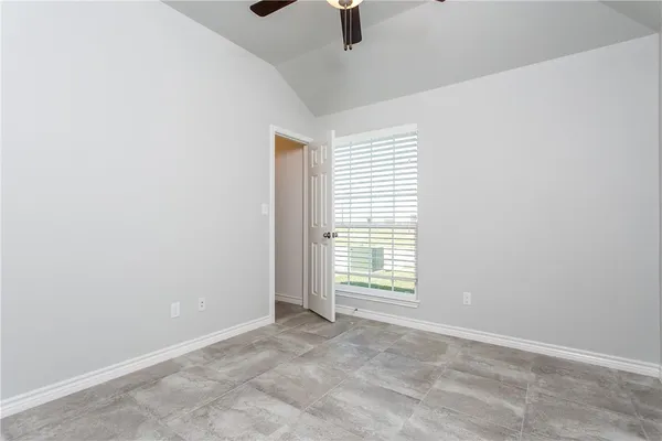 an empty room with windows and fan