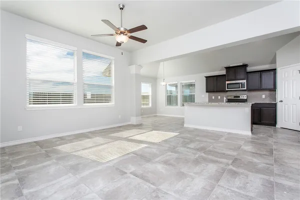 a view of kitchen with microwave a stove and a refrigerator
