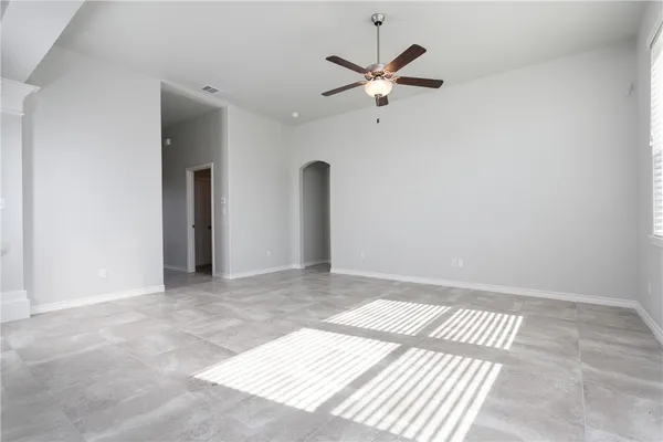 an empty room with a ceiling fan and window