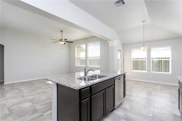 a bathroom with a granite countertop sink and a window