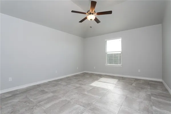 an empty room with a window and a fan