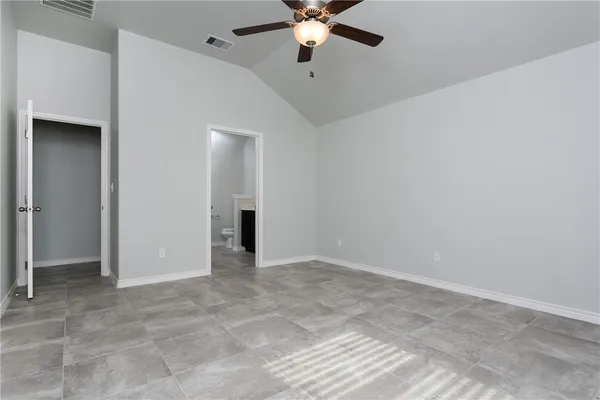 an empty room with closet and a chandelier fan