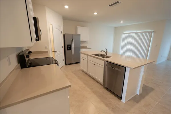 a kitchen with granite countertop white cabinets and stainless steel appliances