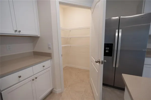 a large white kitchen with kitchen island a sink a stove and a refrigerator