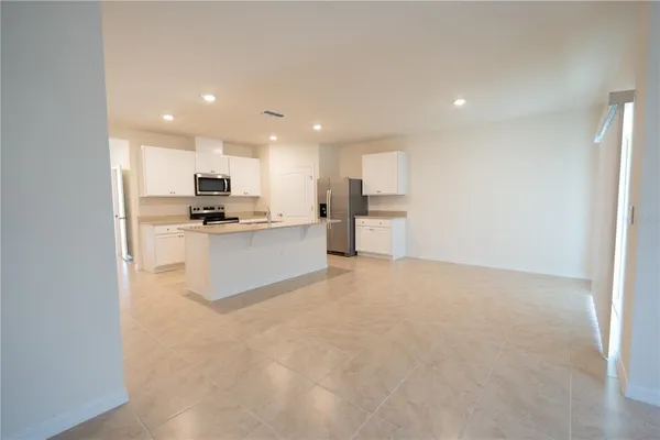 a kitchen with kitchen island a sink and a refrigerator