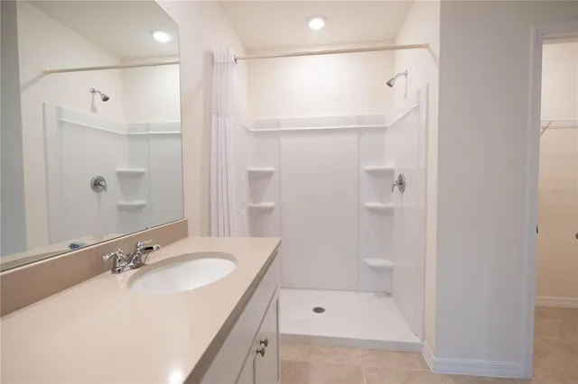 a bathroom with a granite countertop toilet and a shower