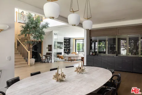a dining room with wooden floor a chandelier a wooden table and chairs