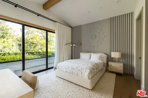 a bedroom with a bed and a large window with balcony view