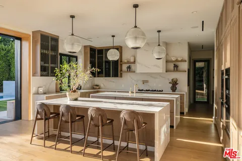 a kitchen with stainless steel appliances a stove a sink island and a refrigerator