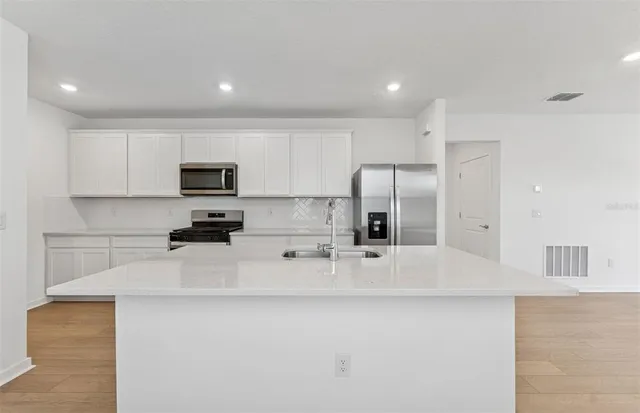 a kitchen with stainless steel appliances a refrigerator sink stove microwave and cabinets