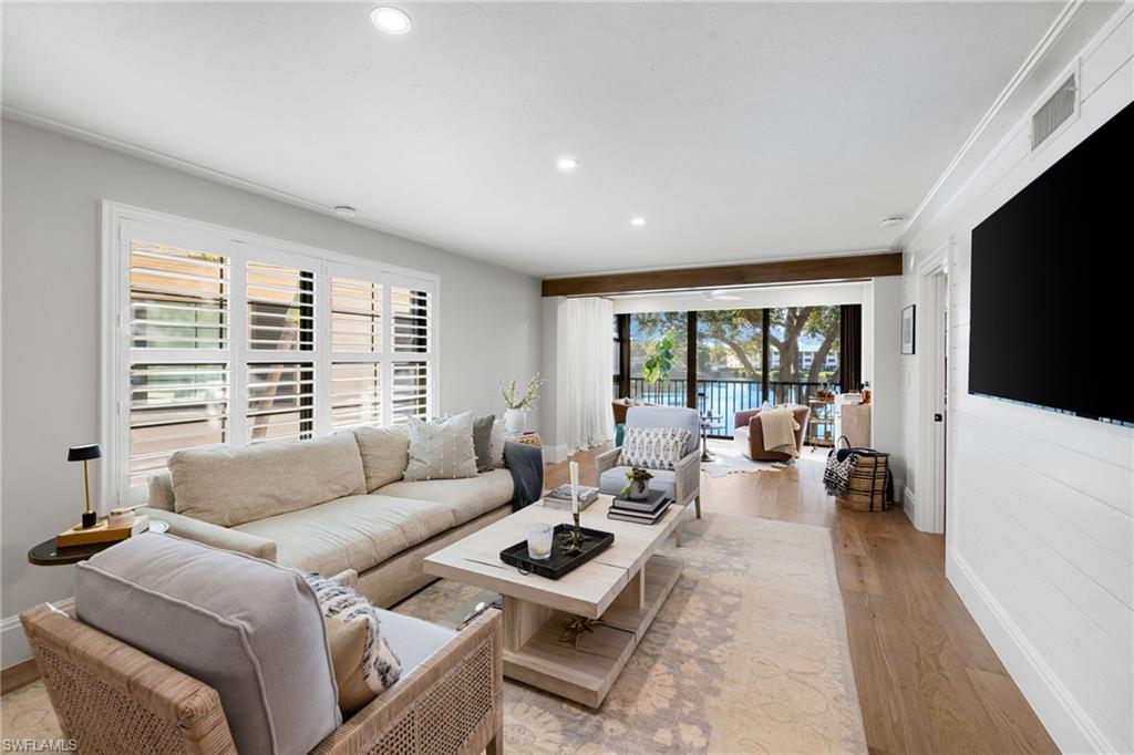 a living room with furniture large window and a flat screen tv