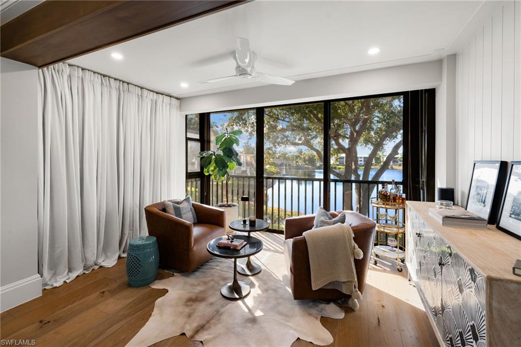 a living room with furniture and floor to ceiling windows