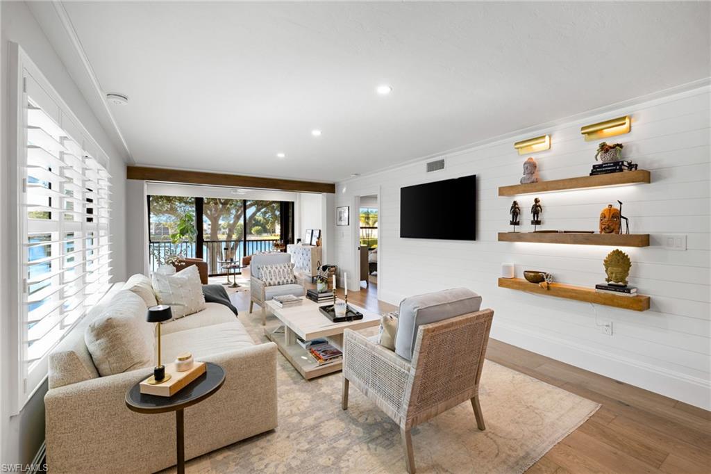 3135 Riviera Drive, Unit B205 Naples, FL 34103 - Photo 12 of 48 a living room with furniture and a flat screen tv