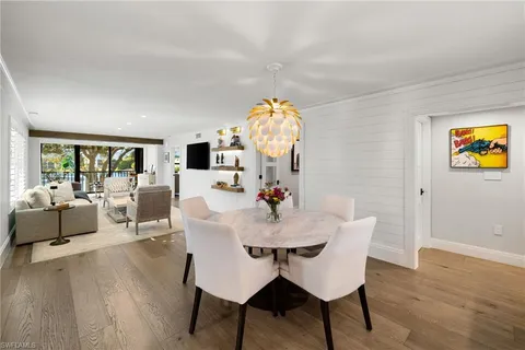 a kitchen with stainless steel appliances kitchen island granite countertop a sink dishwasher and refrigerator with wooden floor