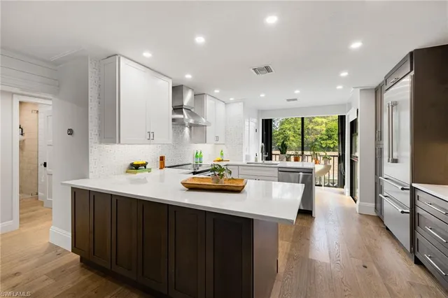 a kitchen with stainless steel appliances a stove a sink a refrigerator and cabinets
