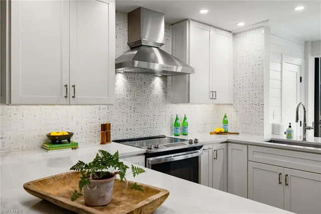 a kitchen with kitchen island granite countertop a sink a counter top space and stainless steel appliances