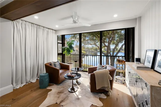 a living room with furniture and floor to ceiling windows
