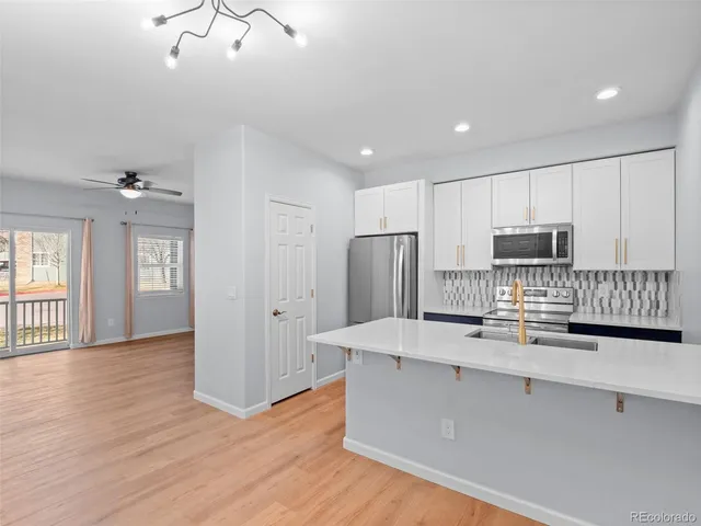 a kitchen with stainless steel appliances a refrigerator and a stove top oven