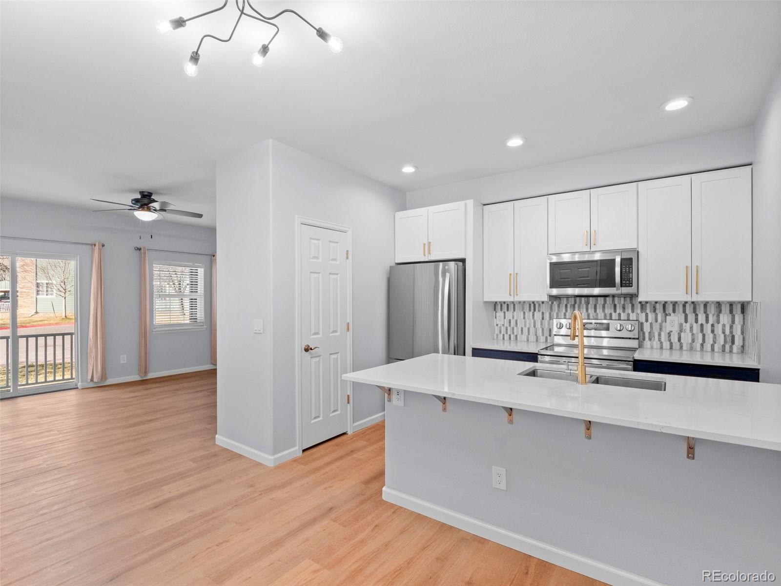 5335 Pecos Way, Unit 4 Denver, CO 80221 - Photo 1 of 25 a kitchen with stainless steel appliances a refrigerator and a stove top oven