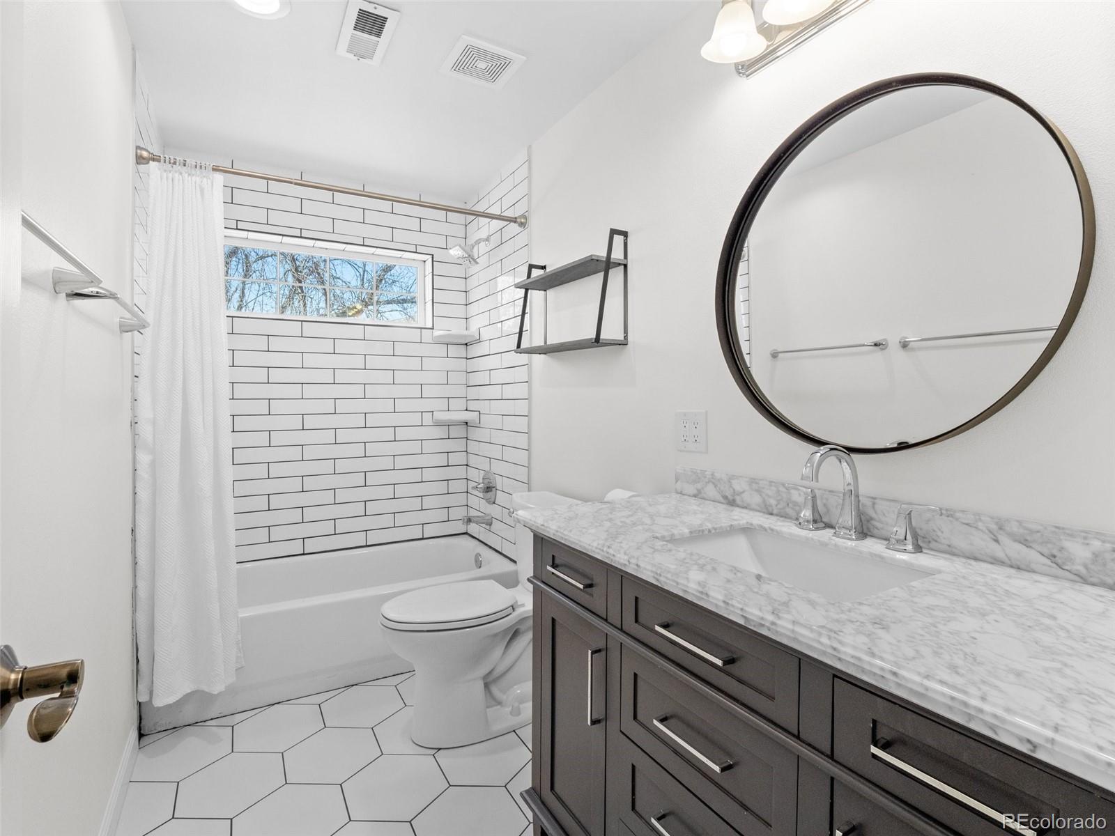 5335 Pecos Way, Unit 4 Denver, CO 80221 - Photo 22 of 25 a bathroom with a granite countertop toilet a sink and a mirror