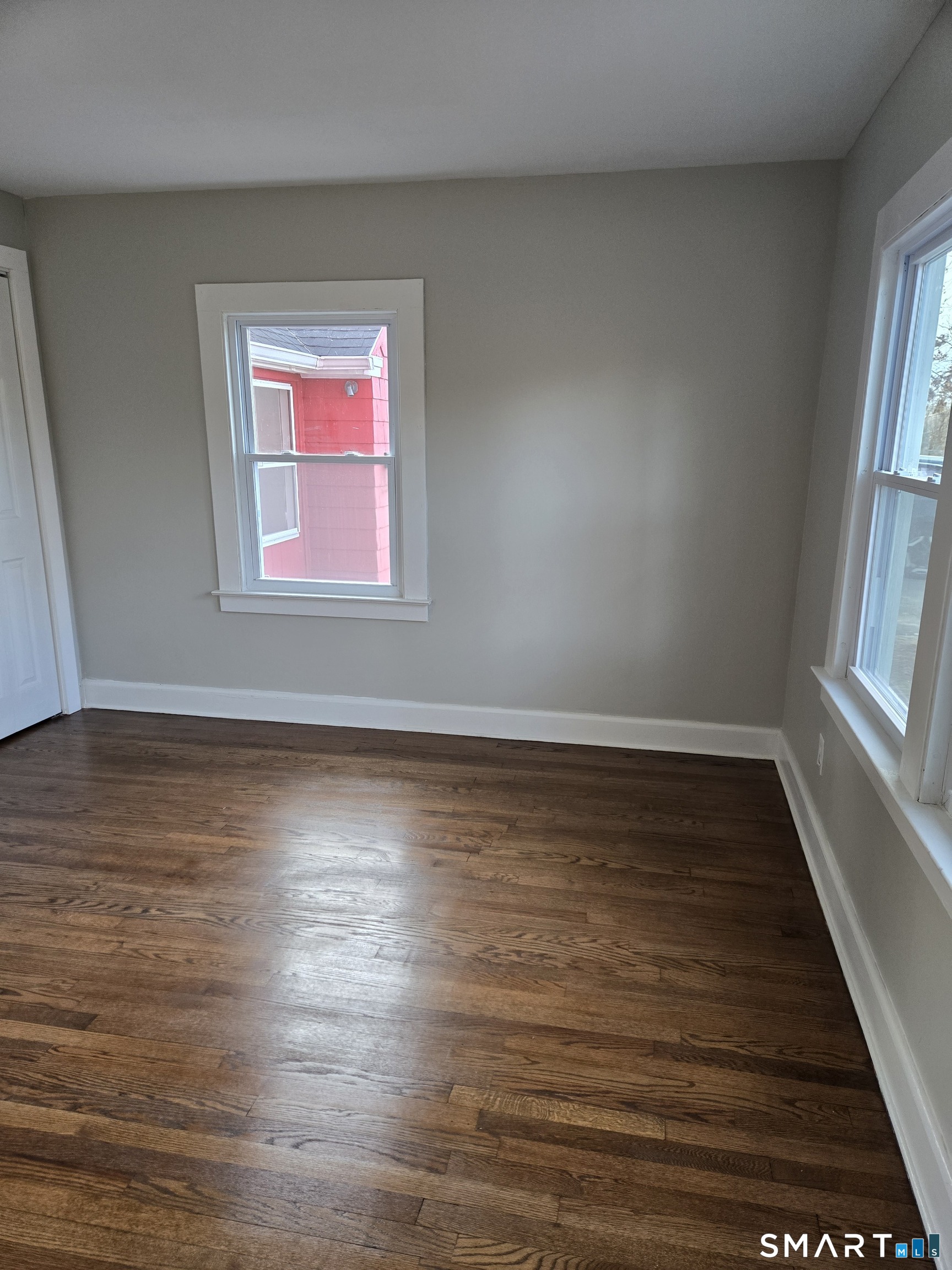 242 Elm Street Enfield, CT 06082 - Photo 12 of 21 a view of an empty room with wooden floor and a window
