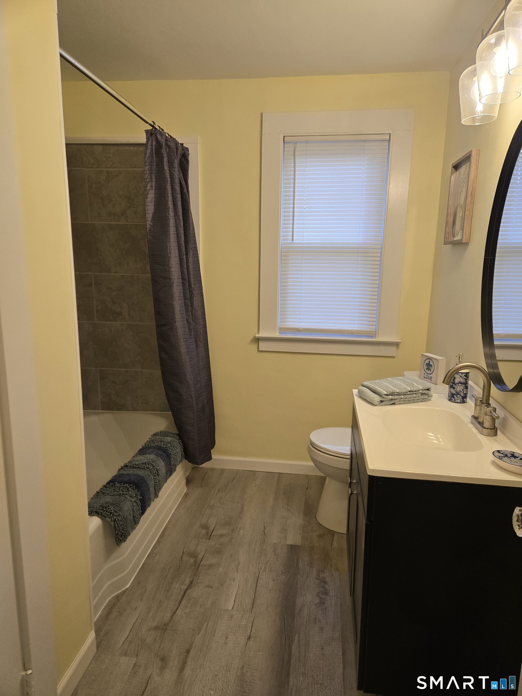 242 Elm Street Enfield, CT 06082 - Photo 6 of 21 a bathroom with a sink a toilet a mirror and shower