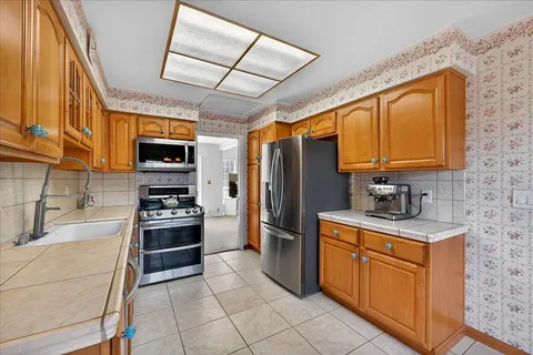 a kitchen with stainless steel appliances granite countertop a stove microwave and sink