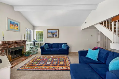 a living room with furniture a flat screen tv and a fireplace