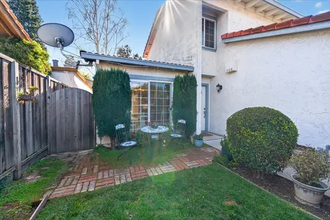 a view of a house with backyard and sitting area