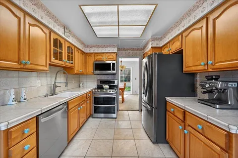 a kitchen with stainless steel appliances granite countertop a stove refrigerator sink and microwave