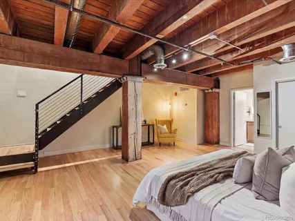 a spacious bedroom with a bed and a wooden floor