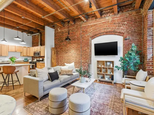 a living room with furniture a flat screen tv and a fireplace