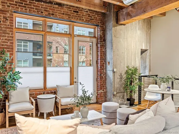 a living room with furniture and potted plants