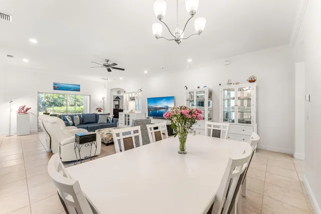 a view of a dining room with furniture and a chandelier fan