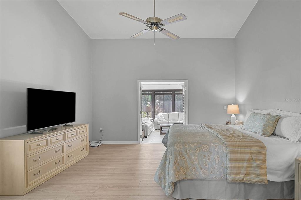 4312 Pro Am Avenue East Bradenton, FL 34203 - Photo 12 of 37 a bedroom with a flat screen tv on dresser and a chandelier