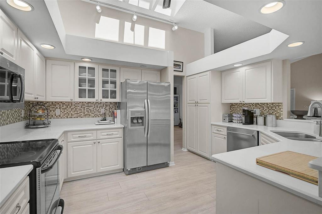 4312 Pro Am Avenue East Bradenton, FL 34203 - Photo 20 of 37 a kitchen with white cabinets and stainless steel appliances