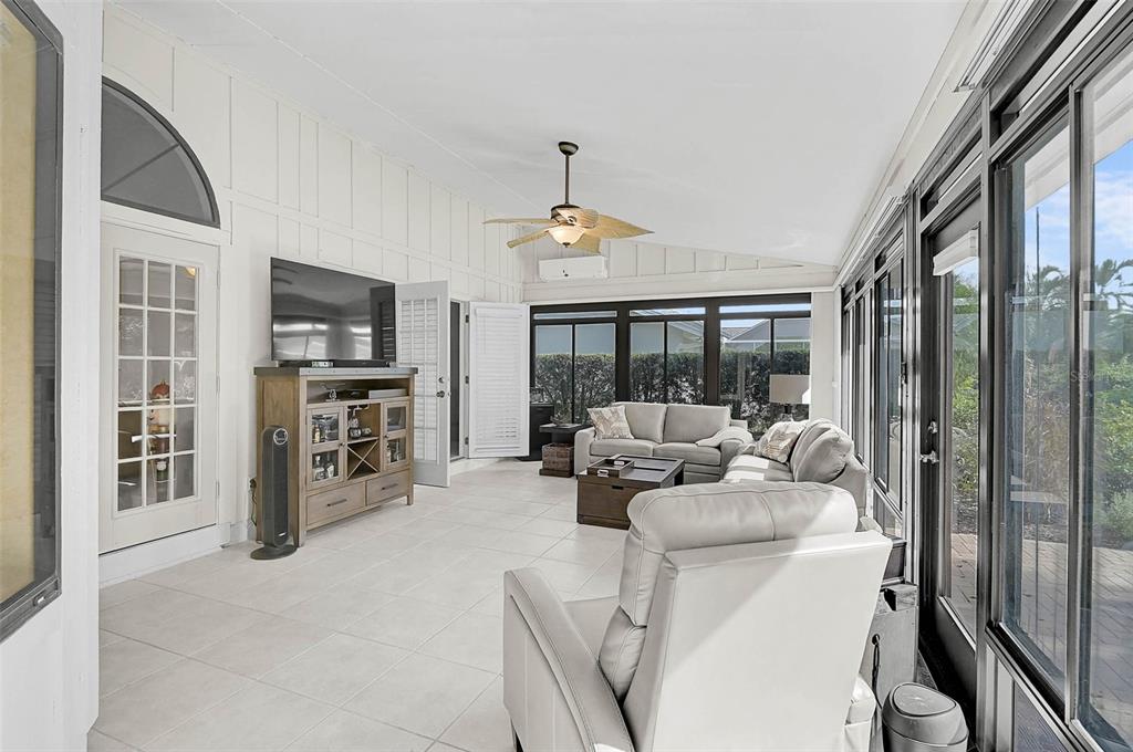 4312 Pro Am Avenue East Bradenton, FL 34203 - Photo 30 of 37 a living room with furniture a flat screen tv and a floor to ceiling window