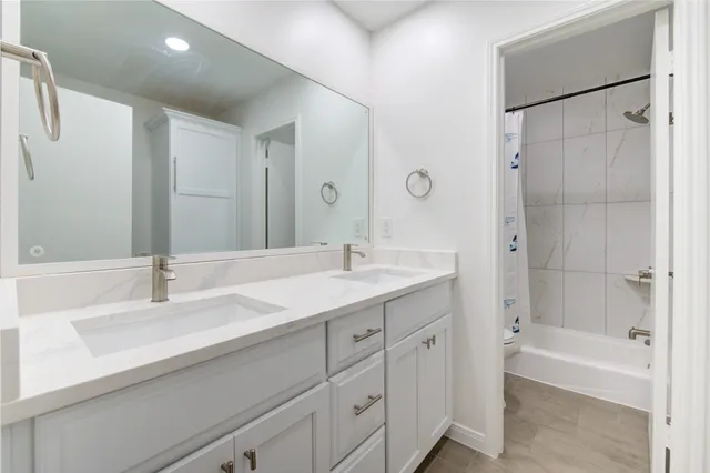 a bathroom with a bathtub shower sink and a mirror