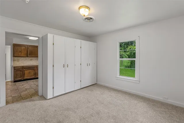 an empty room with windows and cabinet
