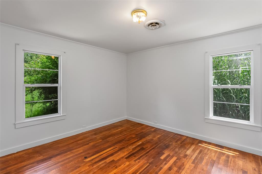 9008 Hosston Vivian Road Vivian, LA 71082 - Photo 17 of 30 a view of an empty room with wooden floor and a window