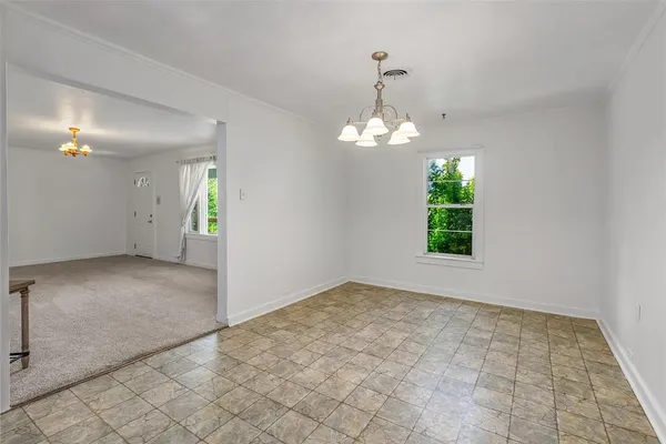 an empty room with windows and chandelier