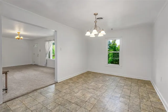 an empty room with windows and chandelier