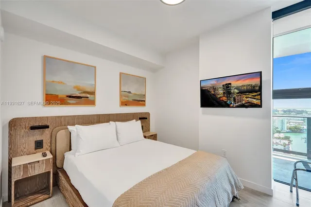 a bedroom with a bed and a flat screen tv